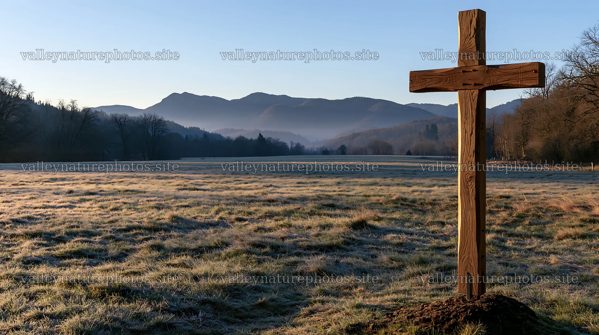 Carved oak cross in frosted meadow with mountains in background – nature photography 10608x5938