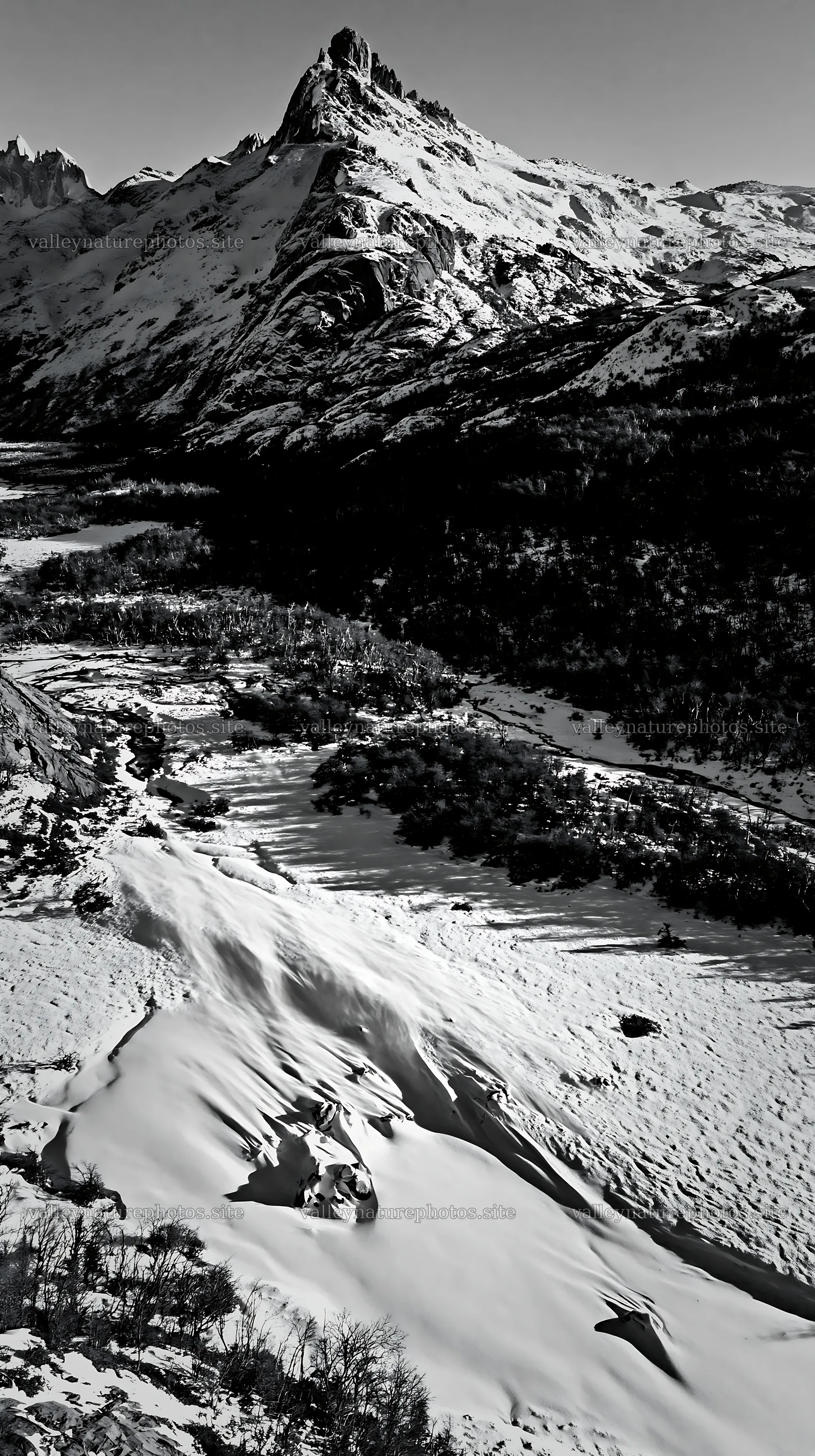 Snowy meadow valley with mountains in aerial view – nature photography 5938x10608