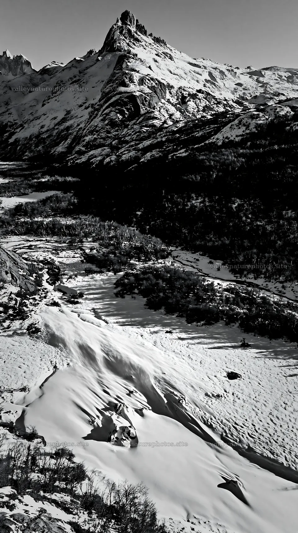 Snowy meadow valley with mountains in aerial view – nature photography 5938x10608