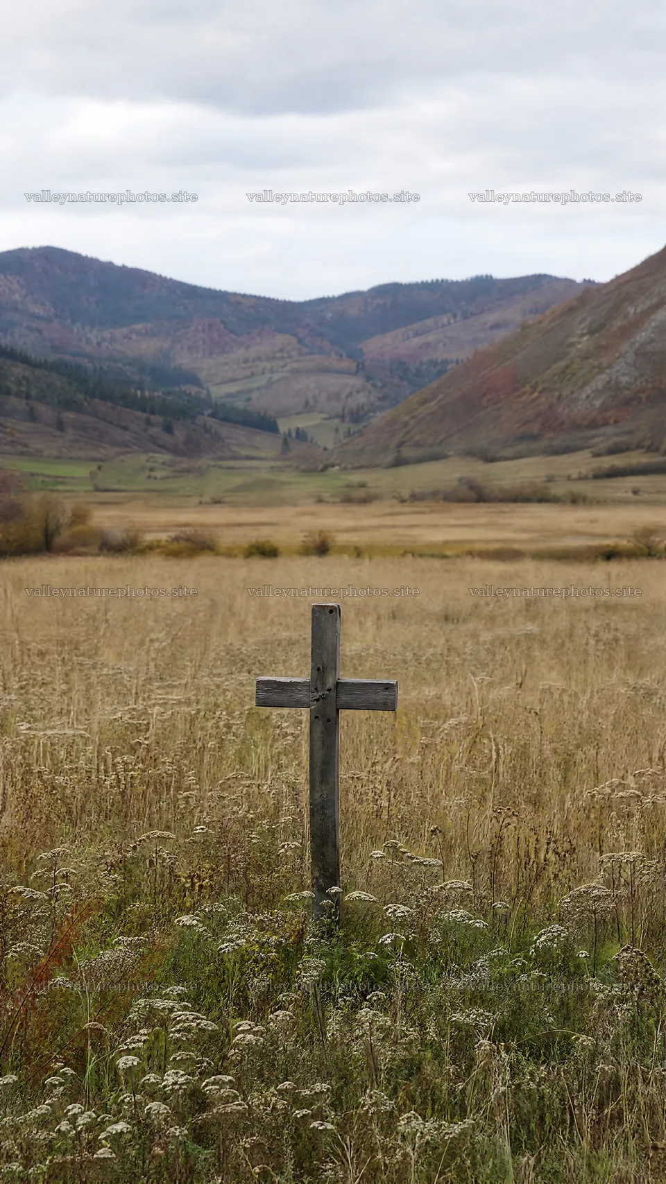 Aged Christian cross in deep mountain valley – nature photography 5952x10584