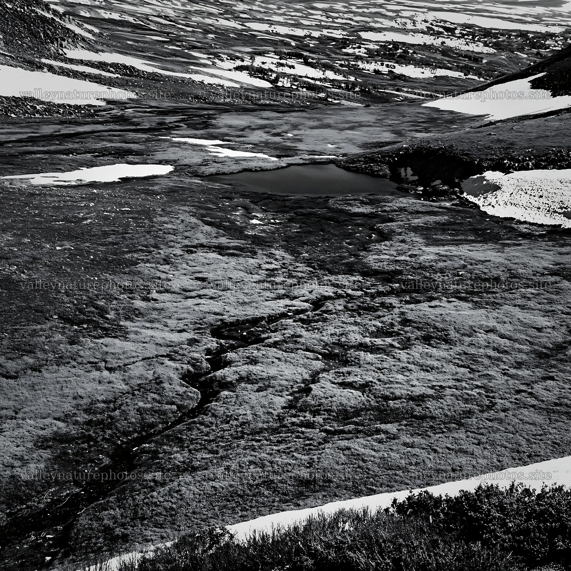 Aerial view of snowy meadow valley with dark water pool – nature photography 7938x7938