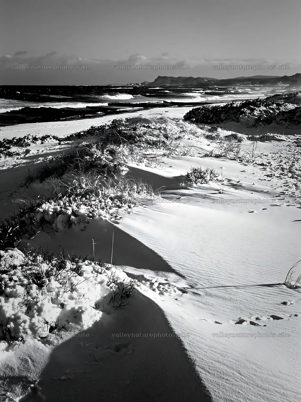 Snowy beach meadow with waves and distant cliffs – nature photography 6866x9174